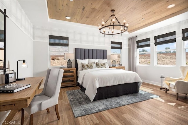 bedroom featuring wood finished floors, a raised ceiling, wood ceiling, and a chandelier