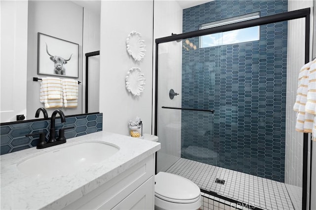 full bathroom featuring vanity, toilet, tasteful backsplash, and tiled shower