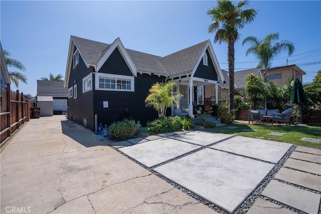 back of property featuring driveway and fence