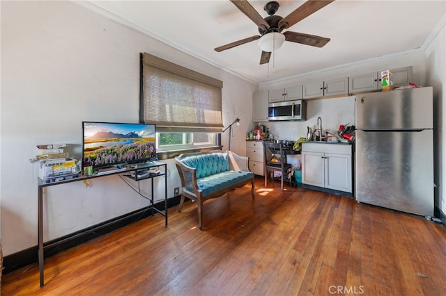 living area with ceiling fan, hardwood / wood-style flooring, and ornamental molding