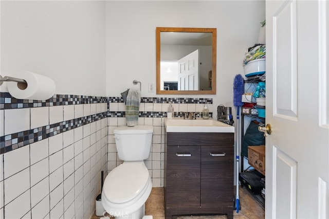 bathroom featuring a wainscoted wall, toilet, tile walls, and vanity