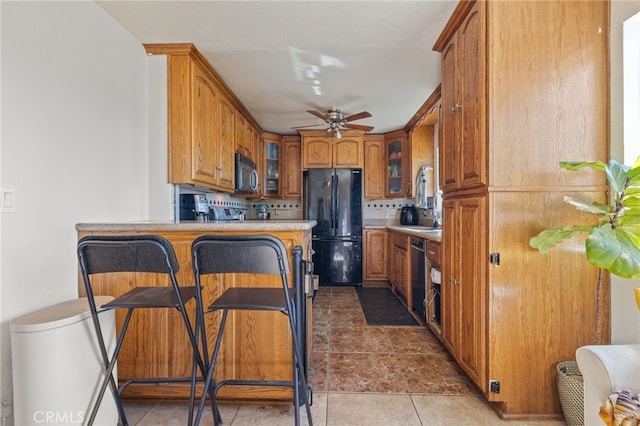 kitchen featuring brown cabinets, freestanding refrigerator, glass insert cabinets, dishwasher, and ceiling fan