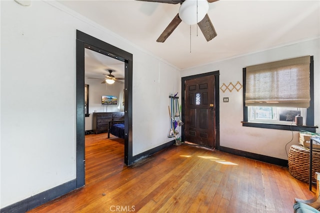 entrance foyer featuring hardwood / wood-style floors, baseboards, ceiling fan, and crown molding