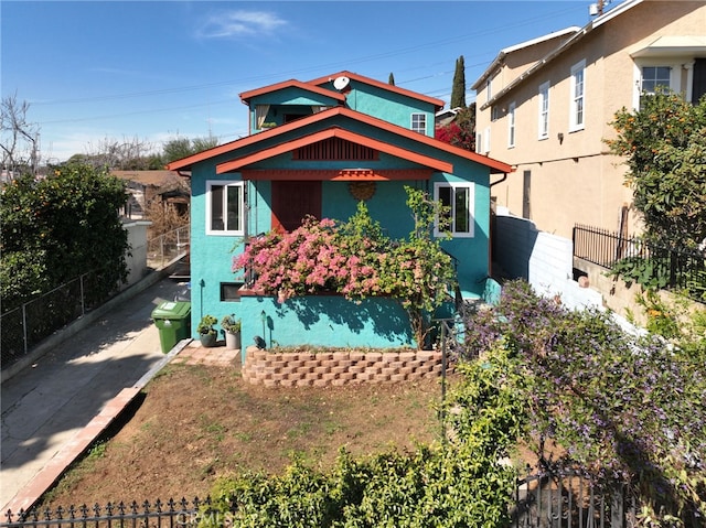 view of front facade with stucco siding and fence