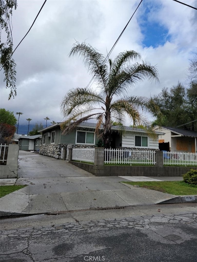 view of front facade with driveway and a fenced front yard