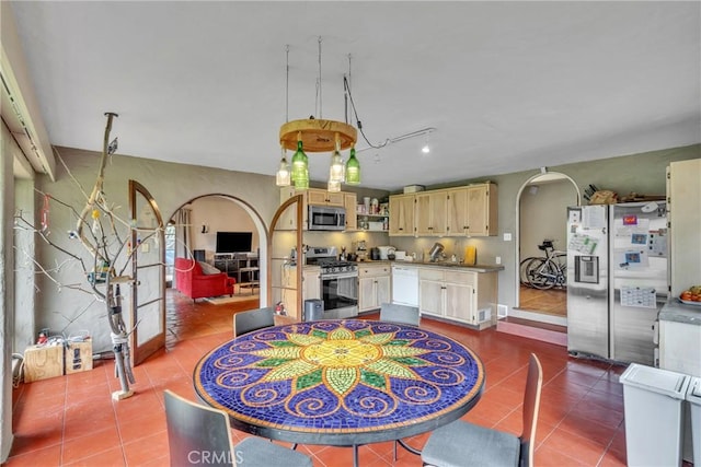 dining room featuring arched walkways, dark tile patterned floors, and track lighting