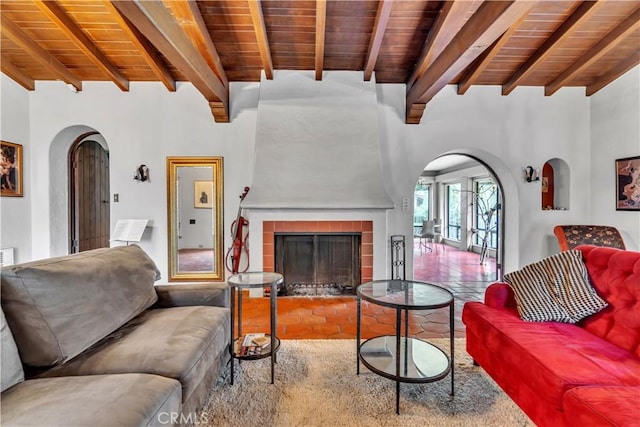 living area with arched walkways, a fireplace, and wood ceiling