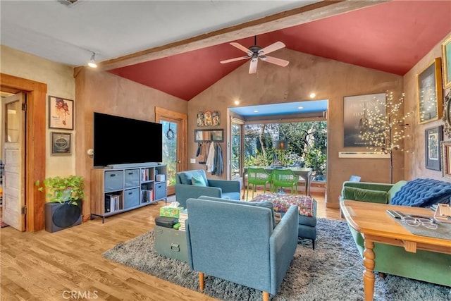 living area with vaulted ceiling with beams, a ceiling fan, and wood finished floors