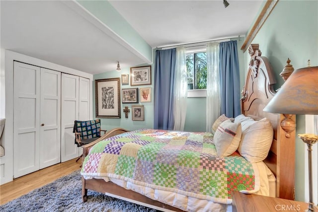 bedroom with vaulted ceiling with beams and wood finished floors