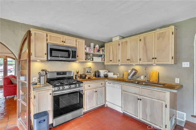 kitchen with visible vents, light brown cabinetry, a sink, appliances with stainless steel finishes, and dark tile patterned floors