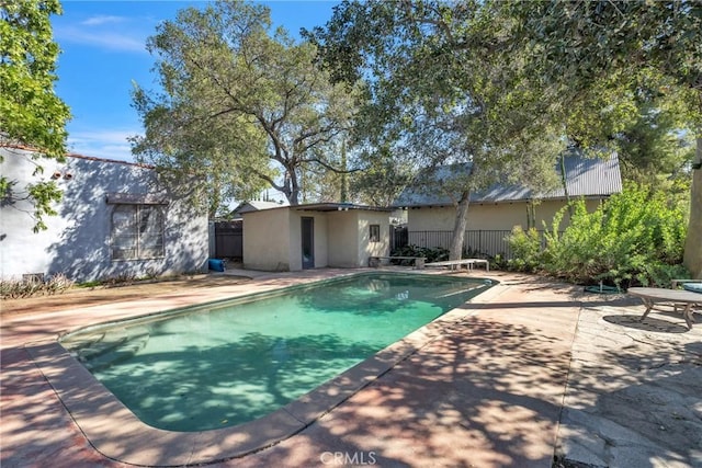 outdoor pool featuring a patio area and fence