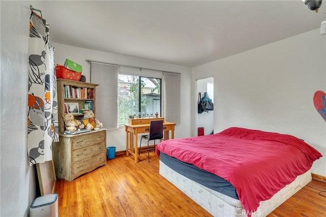 bedroom with wood finished floors and baseboards