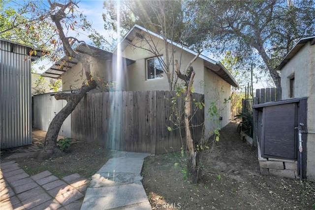 view of property exterior featuring stucco siding and fence