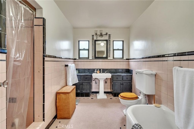 bathroom featuring a shower with curtain, tile walls, a bath, and wainscoting