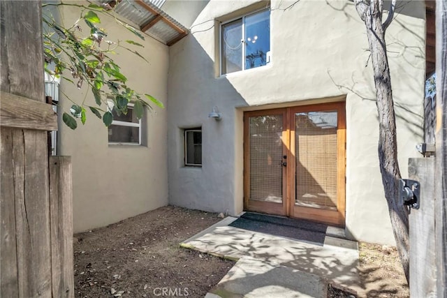 entrance to property with stucco siding and french doors