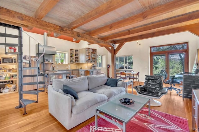 living area featuring beam ceiling, light wood-style flooring, and wooden ceiling