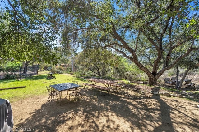 surrounding community with a lawn and outdoor dining area