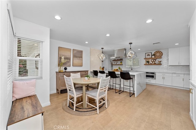 dining room with light wood-style flooring, recessed lighting, visible vents, and baseboards