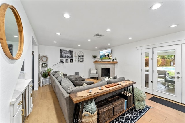 living room with visible vents, recessed lighting, and light wood-style floors