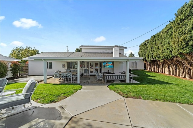 rear view of house featuring a lawn, fence, a patio, and stucco siding