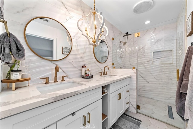 bathroom with a sink, a notable chandelier, tile walls, and double vanity