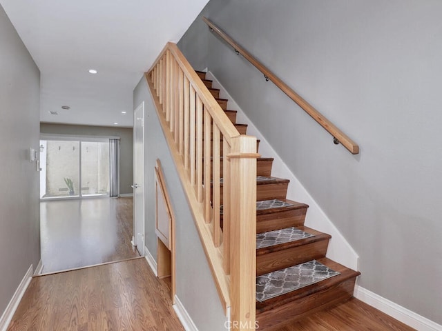 stairs featuring recessed lighting, wood finished floors, and baseboards