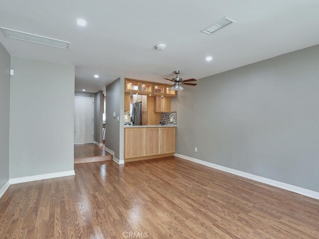 unfurnished living room featuring visible vents, a ceiling fan, wood finished floors, recessed lighting, and baseboards