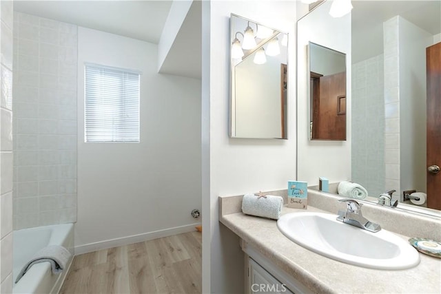 bathroom with vanity, wood finished floors, and baseboards