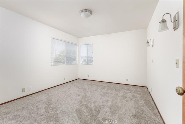 carpeted spare room with baseboards