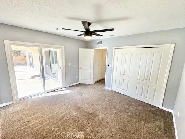 unfurnished bedroom with visible vents, carpet floors, baseboards, and access to exterior