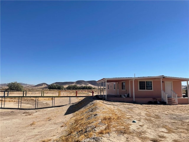 view of yard featuring a mountain view, entry steps, and fence