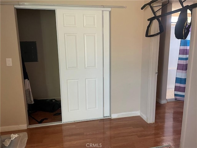 unfurnished bedroom featuring a closet, baseboards, and wood finished floors