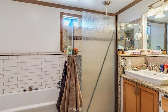 bathroom featuring vanity, ornamental molding, a tub, and walk in shower