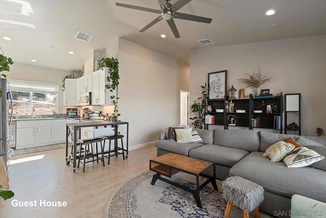 living room featuring light wood-style flooring, recessed lighting, a ceiling fan, and visible vents