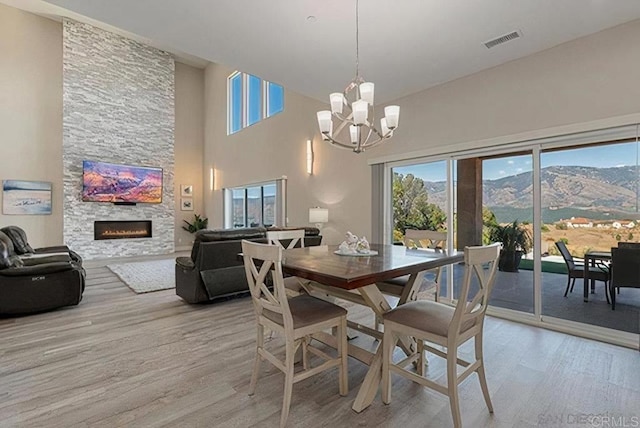 dining space with visible vents, an inviting chandelier, a healthy amount of sunlight, and light wood finished floors