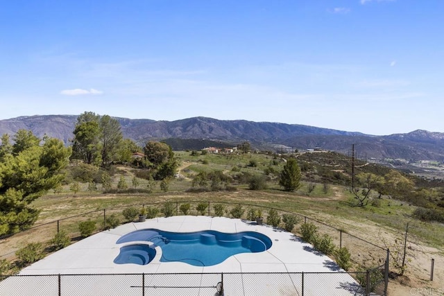 view of pool with a mountain view and fence