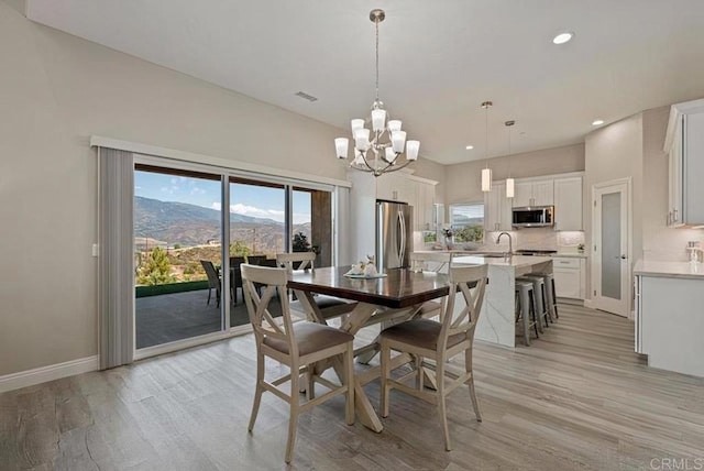 dining area with visible vents, baseboards, a notable chandelier, and light wood finished floors