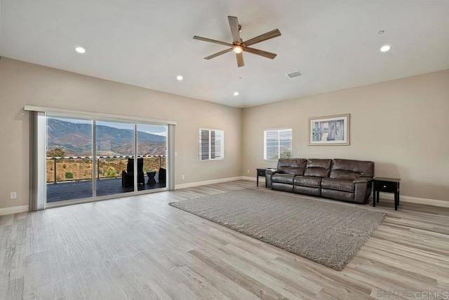 living room with plenty of natural light, a ceiling fan, and wood finished floors