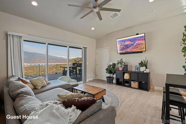 living area featuring a ceiling fan, baseboards, visible vents, lofted ceiling, and light wood-type flooring