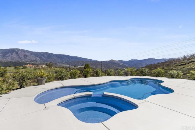 view of swimming pool with a mountain view and a pool with connected hot tub