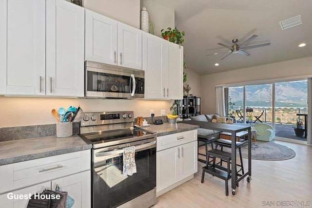 kitchen with light wood finished floors, visible vents, ceiling fan, white cabinets, and stainless steel appliances