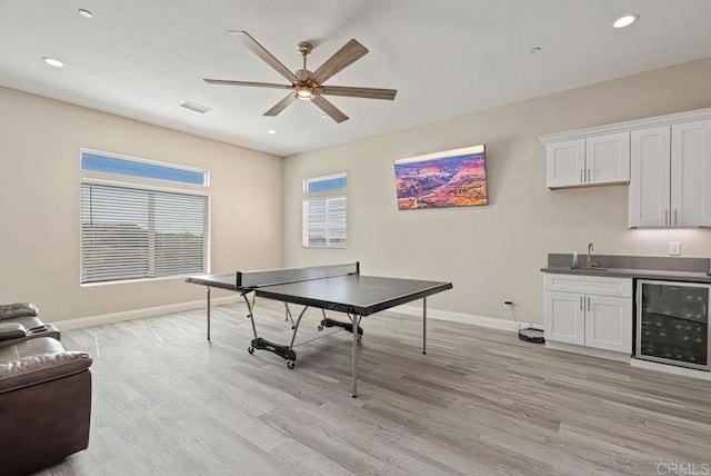 playroom featuring a ceiling fan, beverage cooler, visible vents, a sink, and light wood-type flooring