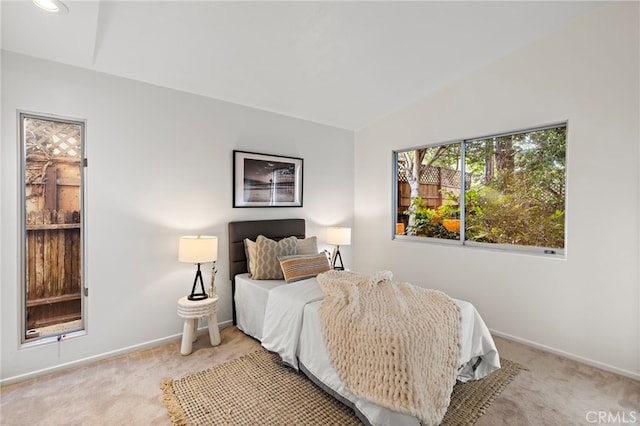 carpeted bedroom with lofted ceiling and baseboards