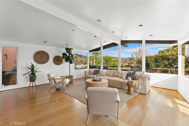 living room featuring lofted ceiling with beams and light wood finished floors