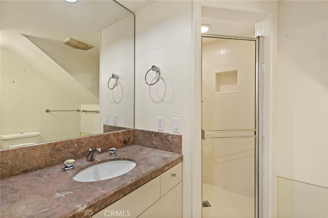 full bathroom featuring visible vents, a shower stall, vanity, and toilet