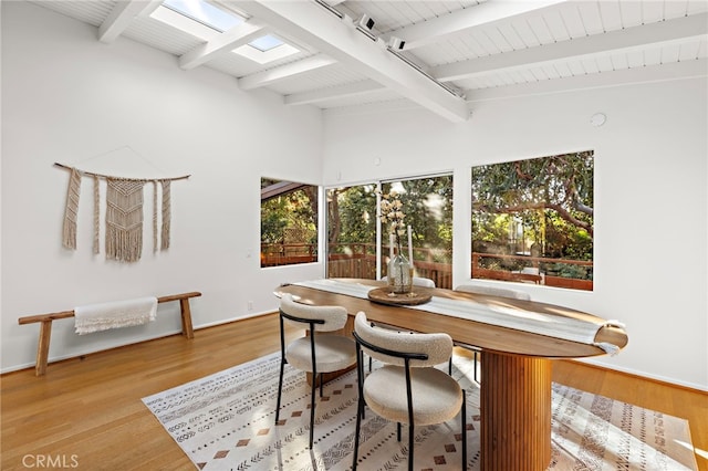 dining space with lofted ceiling with beams, baseboards, wood ceiling, and light wood-style flooring