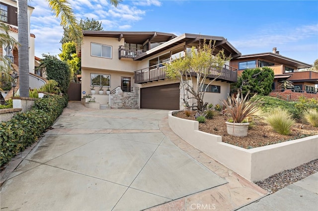 view of front facade featuring stucco siding, driveway, stone siding, an attached garage, and a balcony