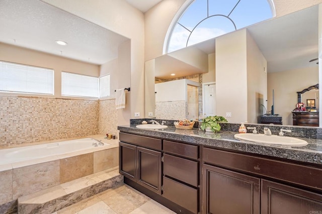 full bathroom with a garden tub, double vanity, and a sink