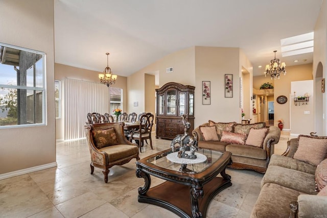 living room with a notable chandelier, visible vents, baseboards, and lofted ceiling