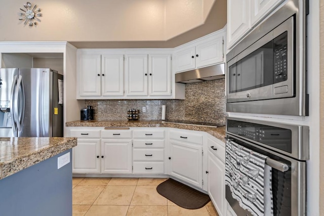 kitchen with under cabinet range hood, white cabinets, appliances with stainless steel finishes, and light tile patterned flooring